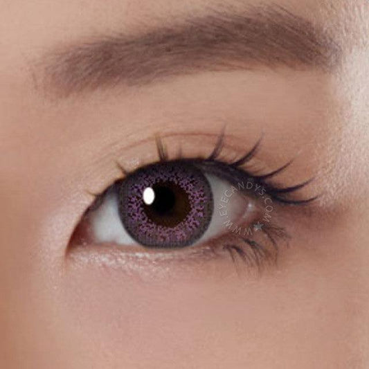 Close-up shot of a model eye wearing Lacelle Colors Jubilee Violet colored contact lens in one eye that is naturally dark-brown with natural eye make up and lashes